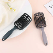 Spazzole per capelli in plastica nera e grigia su sfondo rosa, design rettangolare con setole morbide. Accessori per cura dei capelli, styling.