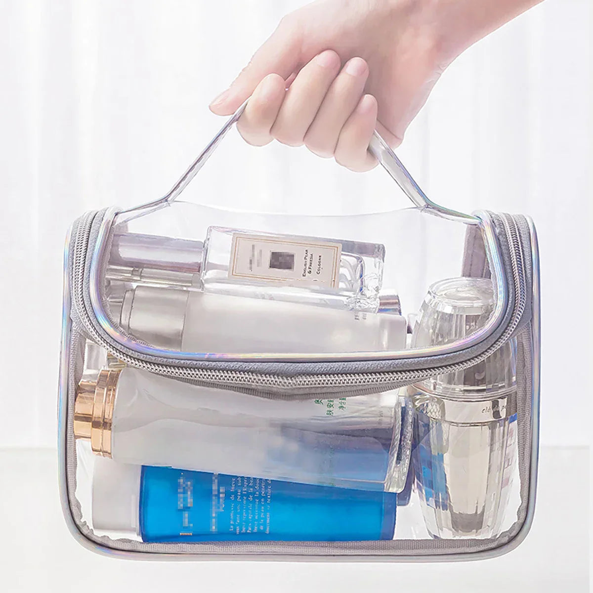 Borsa trasparente da viaggio con manico, contenente flaconi di cosmetici e prodotti per la cura della pelle. Ideale per organizzare articoli da toeletta.