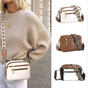 Borsa a tracolla donna in pelle bianca, marrone e nera con cinghia regolabile decorata, tasche con zip, moda autunno, accessorio elegante.