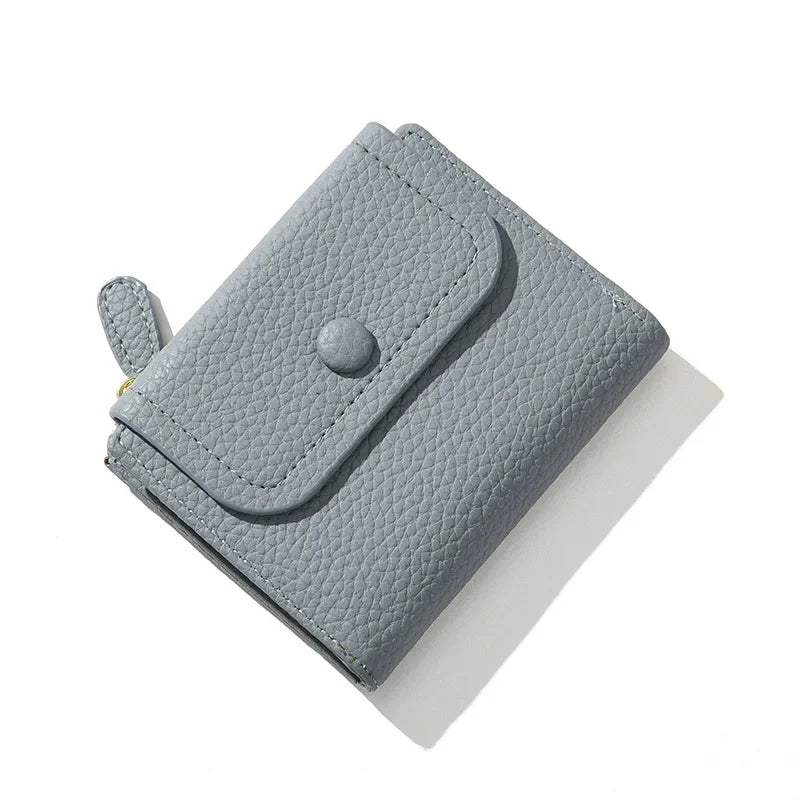 Portafoglio donna in pelle grigia, design compatto con chiusura a bottone e cerniera. Accessorio elegante e funzionale per carte e contanti.