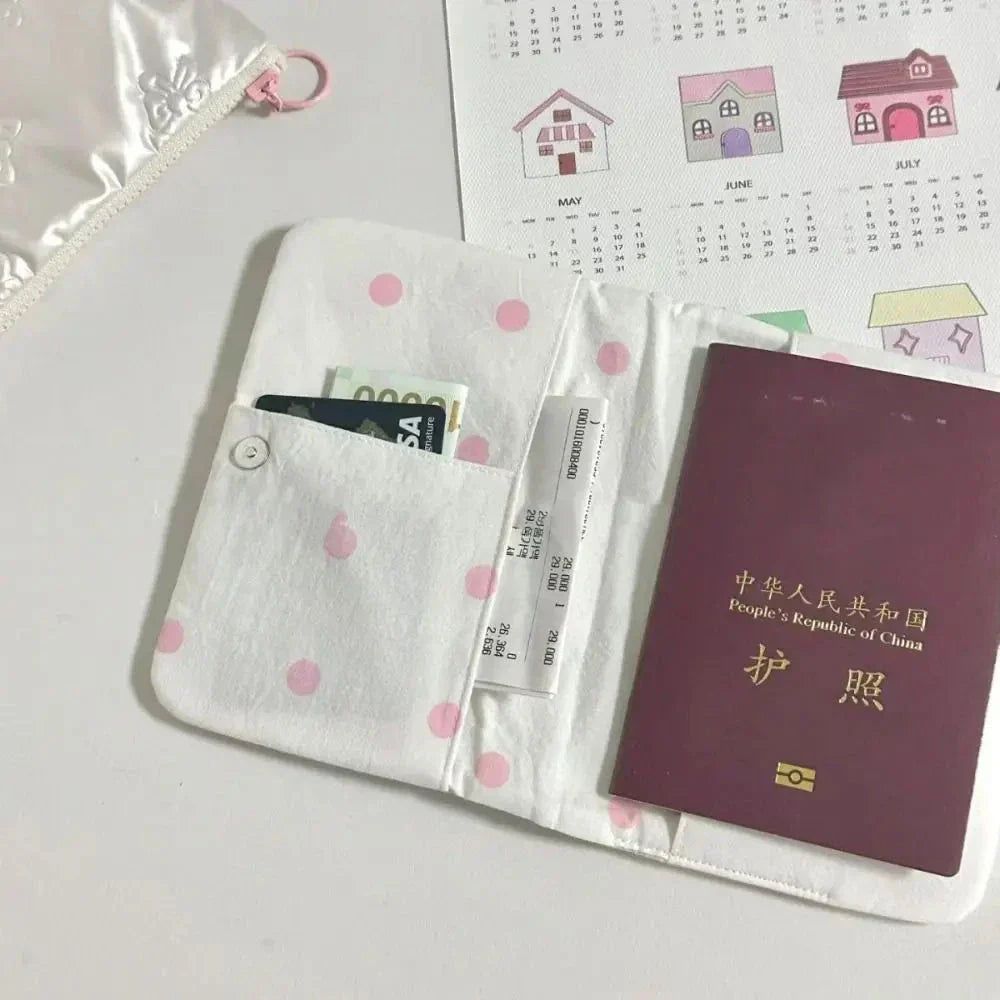 Portafoglio bianco a pois rosa con passaporto cinese, carta Visa e biglietto aereo. Sfondo con calendario e custodia in tessuto.