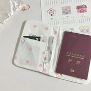 Portafoglio bianco a pois rosa con passaporto cinese, carta Visa e biglietto aereo. Sfondo con calendario e custodia in tessuto.