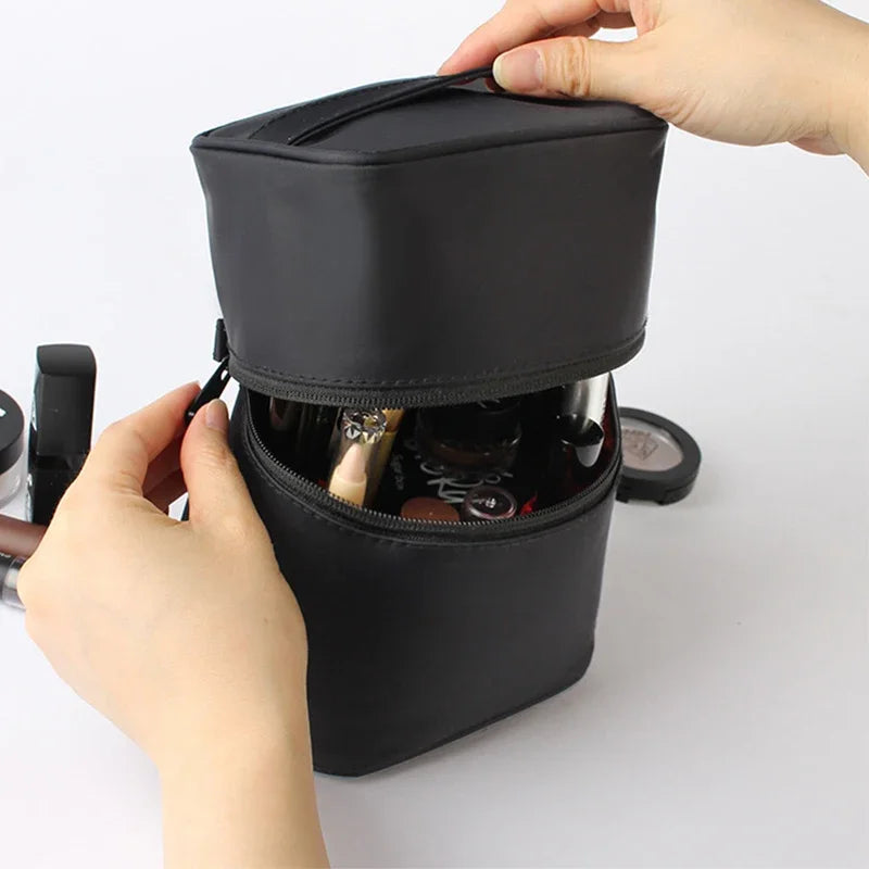 Mani che aprono un beauty case nero in pelle, contenente vari cosmetici. Accessorio trucco, organizer da viaggio, borsa cosmetica elegante.