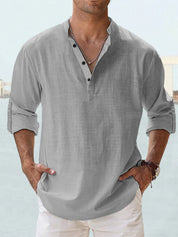 Camicia uomo lino grigia, maniche lunghe arrotolate, colletto alla coreana, abbottonatura parziale, stile casual estivo.