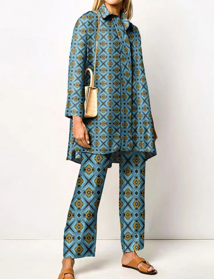 Donna in abito coordinato blu con motivo geometrico, borsa a tracolla beige e sandali marroni. Moda femminile elegante e moderna.