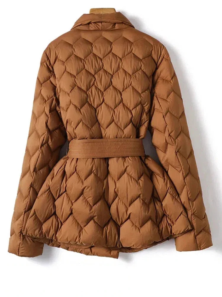 Giacca trapuntata marrone da donna con cintura, design elegante e moderno, ideale per l'inverno. Tessuto caldo e confortevole.