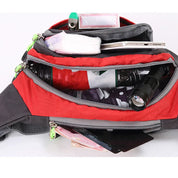 Marsupio rosso multi-tasca aperto, contenente torcia, smartphone, fazzoletti e altri oggetti. Accessorio pratico per escursioni e viaggi.