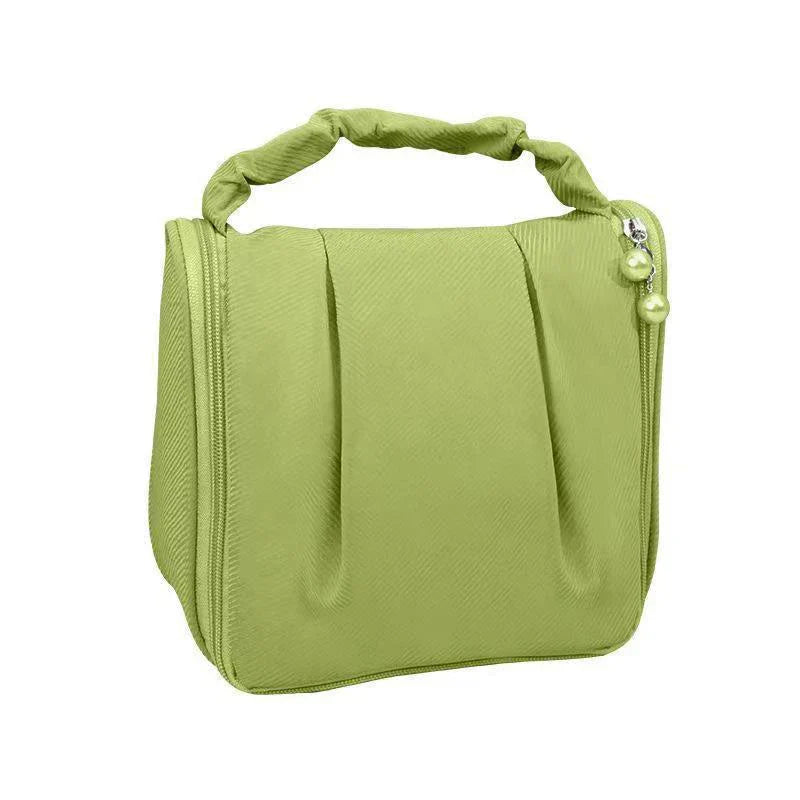 Borsa cosmetica verde chiaro con manico intrecciato, chiusura a zip e decorazione con perle. Ideale per viaggi e organizzazione trucco.