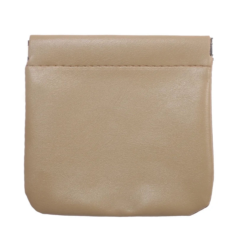 Portamonete in pelle beige, design minimalista, chiusura a scatto. Accessorio elegante per uomo e donna, ideale per monete e piccoli oggetti.