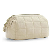 Borsa da toilette trapuntata beige con cerniera dorata, design elegante e spazioso, ideale per viaggi e organizzazione cosmetici.