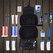 Set da viaggio per igiene personale su sfondo in legno: spazzolini, dentifricio, rasoio, deodorante, shampoo, bagnoschiuma, pettine, salviette, borsa organizer.