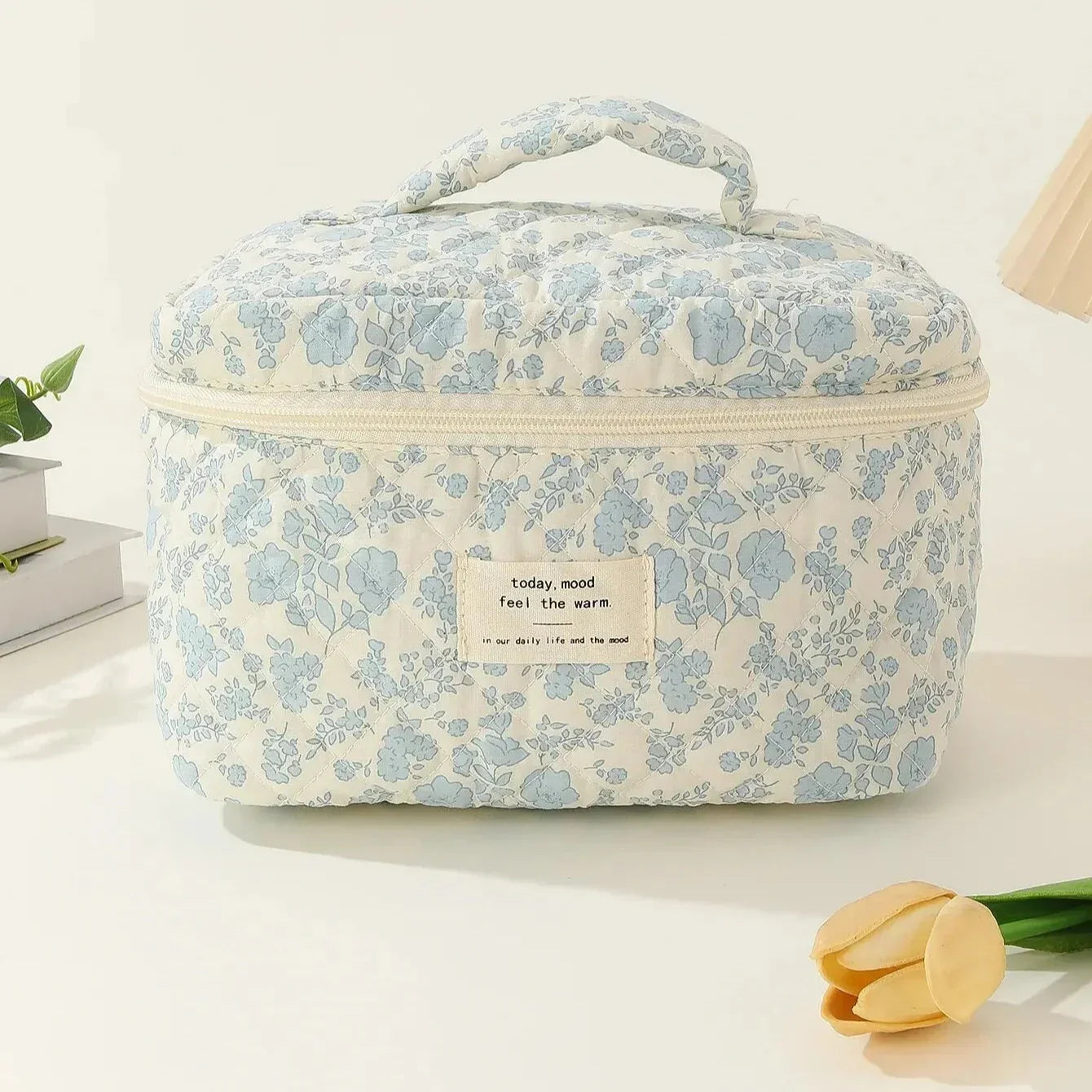Borsa termica floreale in tessuto bianco e blu con manico, ideale per picnic e viaggi. Design elegante e pratico per mantenere cibi freschi.