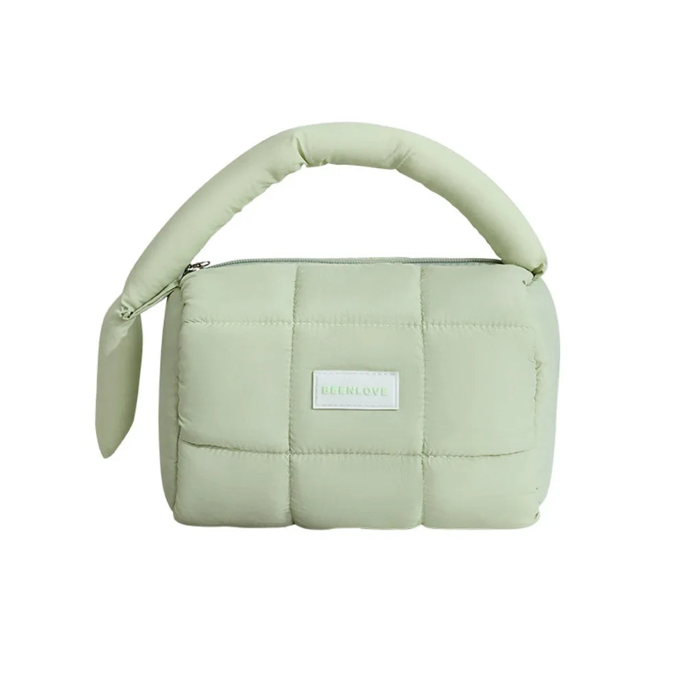 Borsa a mano trapuntata verde chiaro con manico imbottito, design moderno e minimalista, ideale per moda femminile e accessori eleganti.