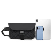 Marsupio nero trapuntato con fibbia, affiancato da un iPhone e un iPad. Accessorio moda unisex, ideale per viaggi e uso quotidiano.