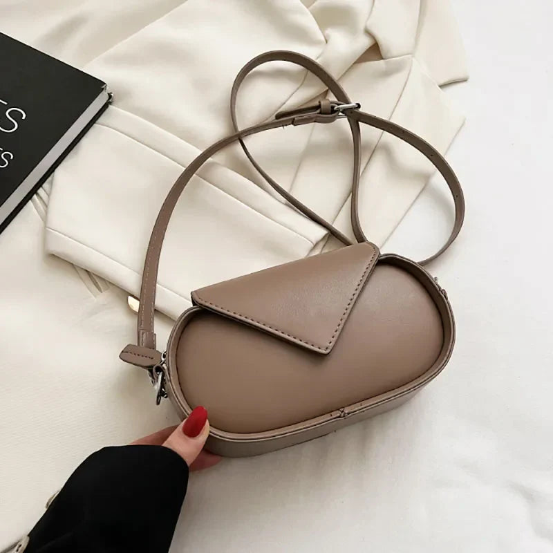 Borsa a tracolla beige in pelle sintetica su sfondo bianco, design moderno ed elegante, accessorio moda donna, perfetta per ogni occasione.