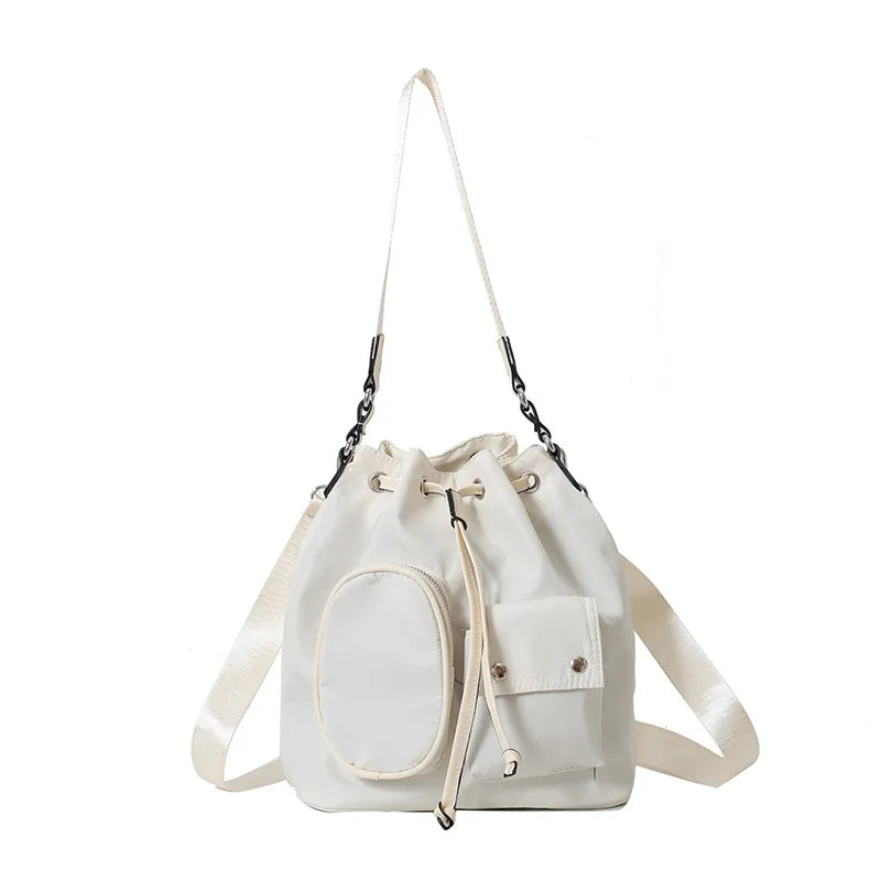 Sacca a secchiello bianca in pelle con tasche esterne, tracolla regolabile, chiusura a coulisse. Borsa elegante e versatile per donna.