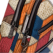 Zaino in pelle patchwork multicolore con cerniere nere, design geometrico. Accessorio moda, stile unico, ideale per viaggi e uso quotidiano.