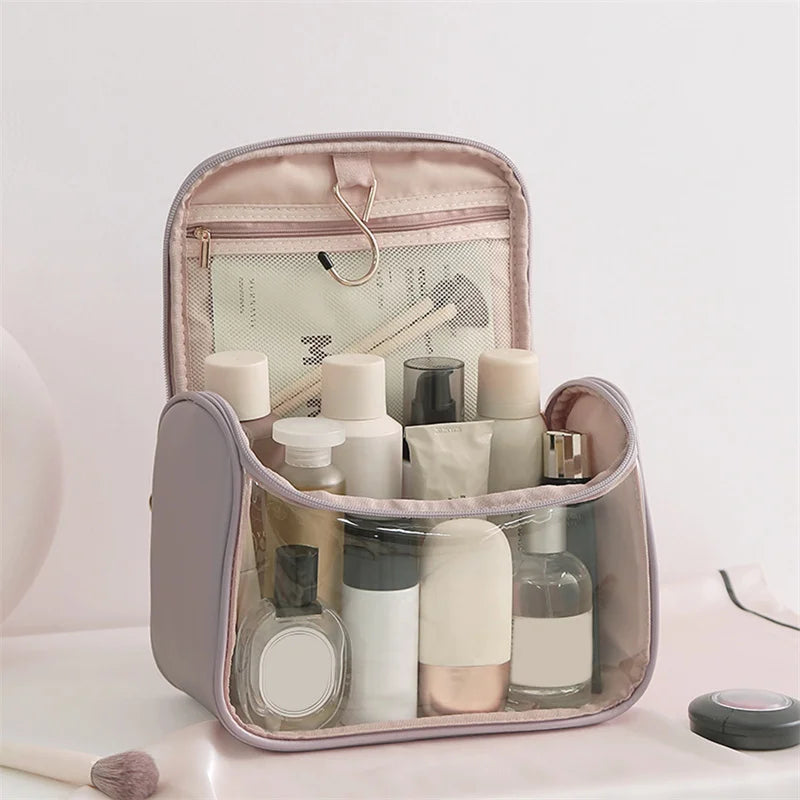 Borsa da toilette trasparente con gancio, contenente flaconi di cosmetici e prodotti per la cura personale. Ideale per viaggi e organizzazione bagno.