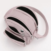 Zaino compatto rosa con tre scomparti con cerniera, design moderno e funzionale, ideale per viaggi e uso quotidiano. Accessorio moda donna.