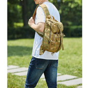 Zaino tattico militare beige indossato da uomo all'aperto, ideale per escursioni e campeggio. Design resistente e multifunzionale.
