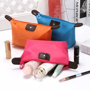 Tre pochette colorate in tessuto impermeabile con cerniera, contenenti cosmetici vari. Ideali per organizzare trucchi e accessori da viaggio.