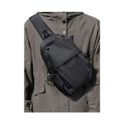 Zaino a tracolla nero su giacca grigia, design moderno e funzionale, ideale per viaggi e uso quotidiano. Accessorio moda unisex.