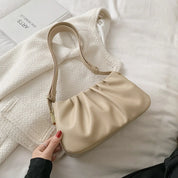 Borsa a spalla beige in pelle su giacca bianca, design elegante e moderno, perfetta per moda femminile, accessorio di tendenza.