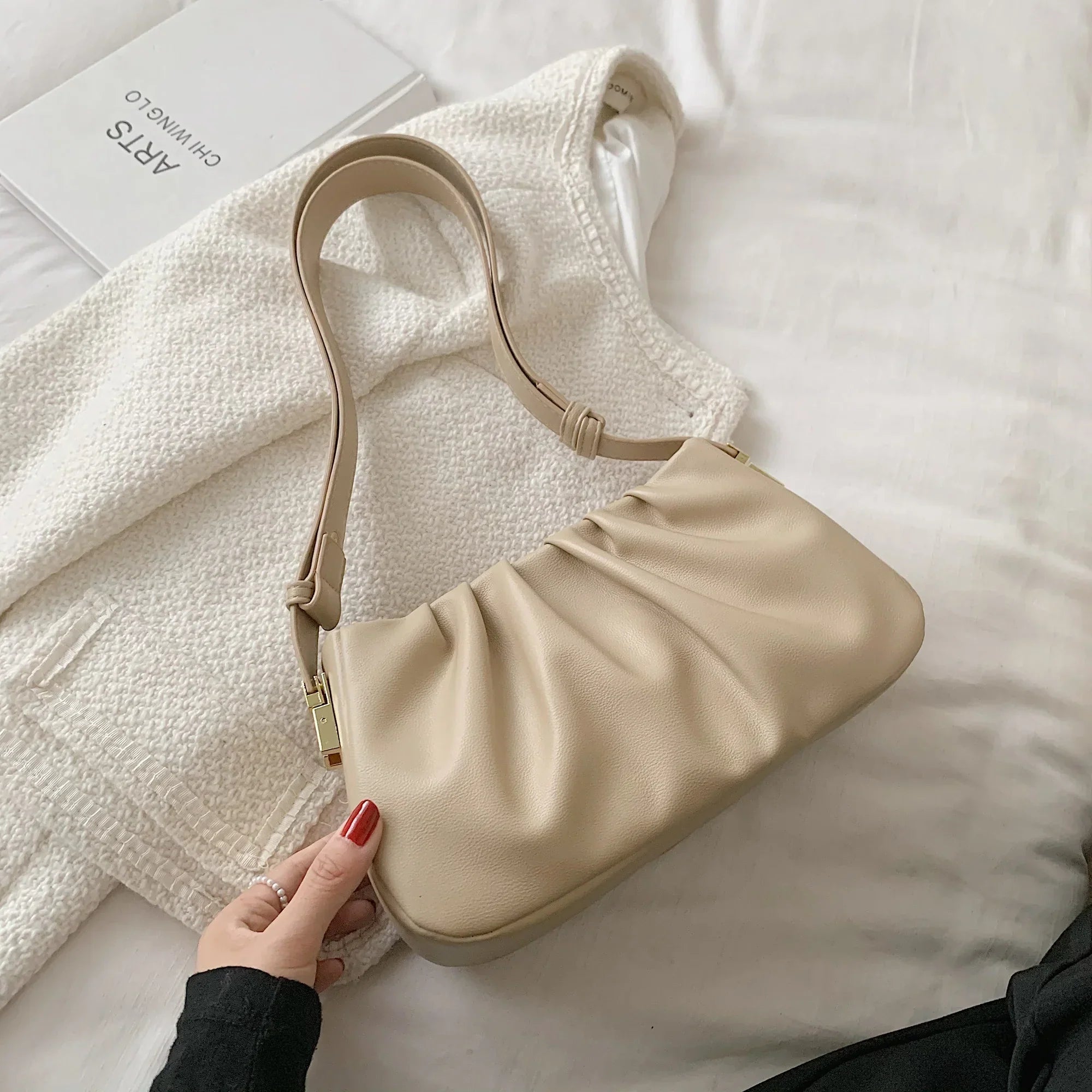 Borsa a spalla beige in pelle su giacca bianca, design elegante e moderno, perfetta per moda femminile, accessorio di tendenza.