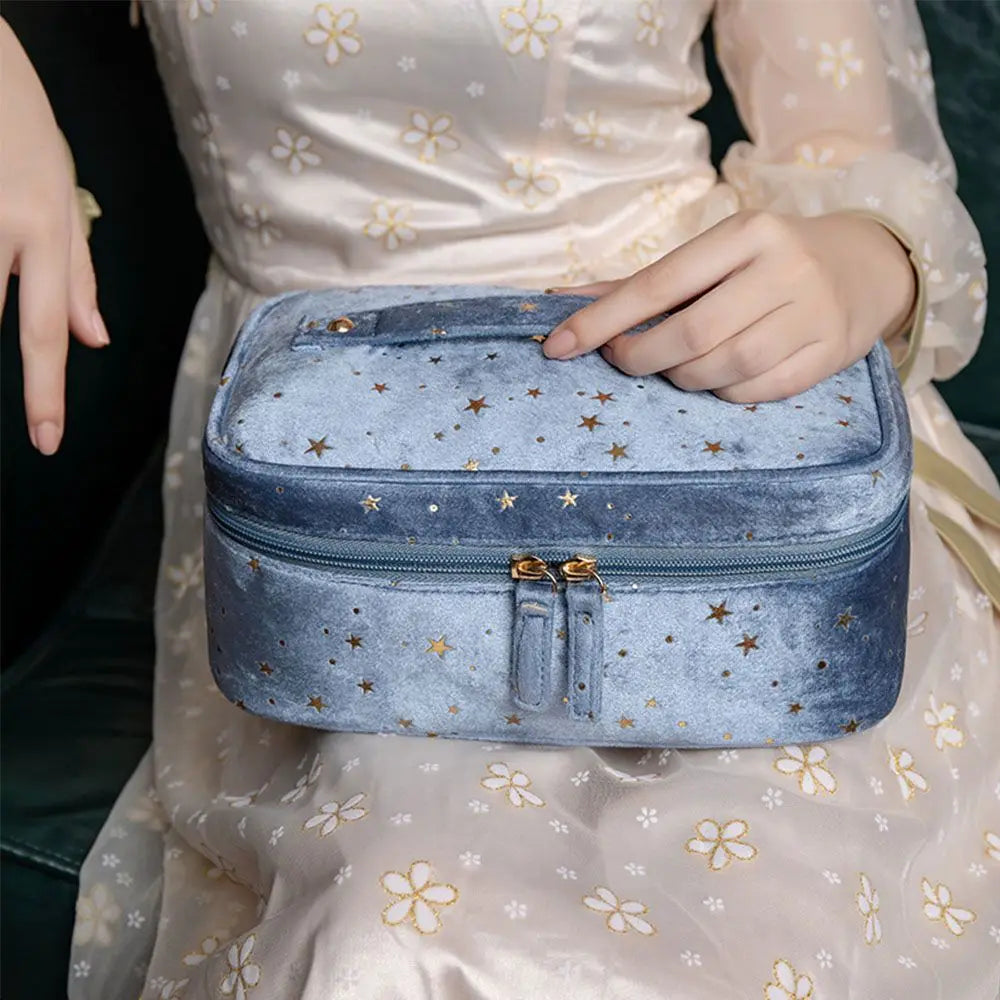 Astuccio cosmetico in velluto blu con stelle dorate, chiusura a zip, dettagli eleganti, ideale per trucco e accessori, design raffinato e moderno.