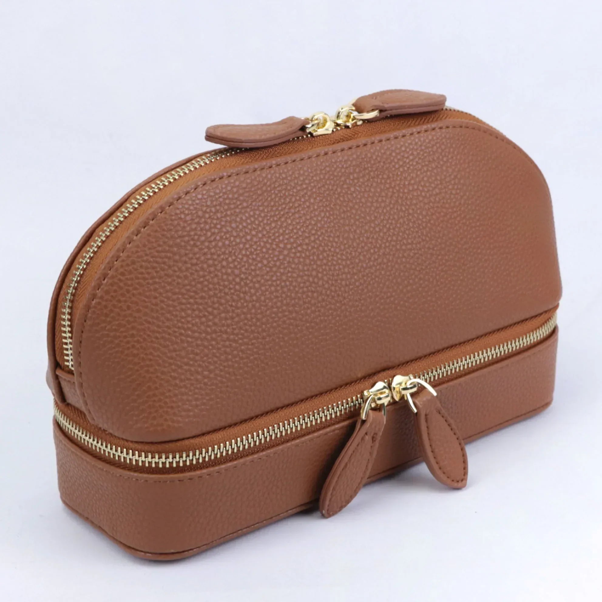 Borsa cosmetica in pelle marrone con doppia cerniera dorata, design elegante e compatto, ideale per organizzare trucchi e accessori da viaggio.