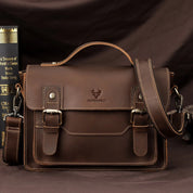 Borsa a tracolla in pelle marrone, design vintage, con fibbie e manico superiore. Ideale per lavoro o scuola. Accessorio moda elegante e funzionale.