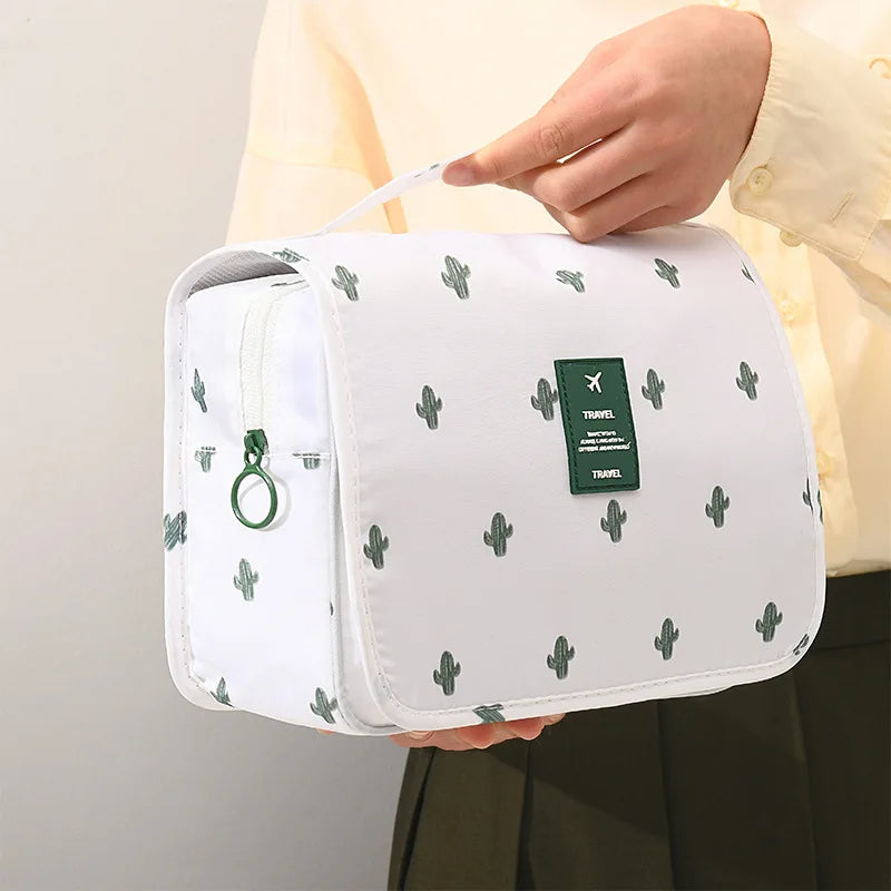 Borsa da viaggio bianca con stampa cactus verdi, manico superiore, chiusura a zip, ideale per organizzare accessori da bagno e cosmetici.