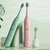 Spazzolini elettrici verde e rosa con testine intercambiabili, design moderno, pulsante di accensione, impostazioni multiple, su sfondo verde.