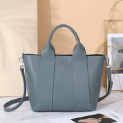 Borsa a mano in pelle blu-grigia con tracolla regolabile, design elegante e moderno, perfetta per l'uso quotidiano e occasioni speciali.