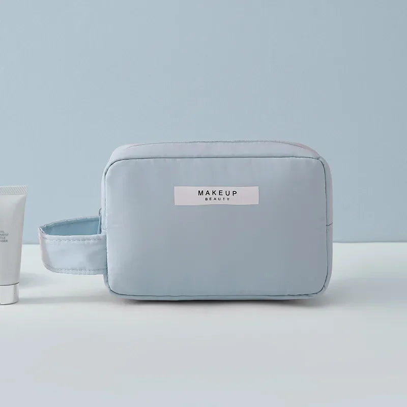 Astuccio trucco azzurro con manico, design minimalista, ideale per cosmetici e accessori viaggio. Elegante e pratico per organizzare il beauty.