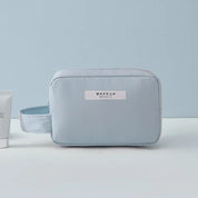 Astuccio trucco azzurro con manico, design minimalista, ideale per cosmetici e accessori viaggio. Elegante e pratico per organizzare il beauty.