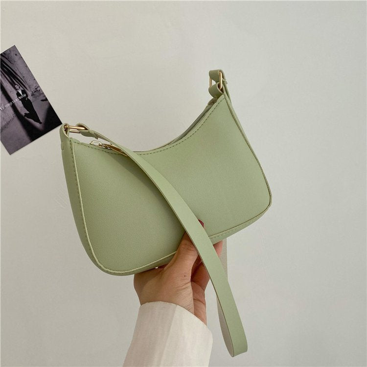 Borsa a tracolla verde chiaro in pelle sintetica, design minimalista, chiusura con zip, ideale per moda donna, accessorio elegante e moderno.