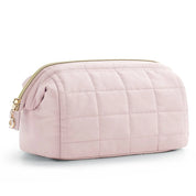 Astuccio da toilette trapuntato rosa chiaro con cerniera dorata, design elegante e spazioso, ideale per viaggi e organizzazione cosmetici.