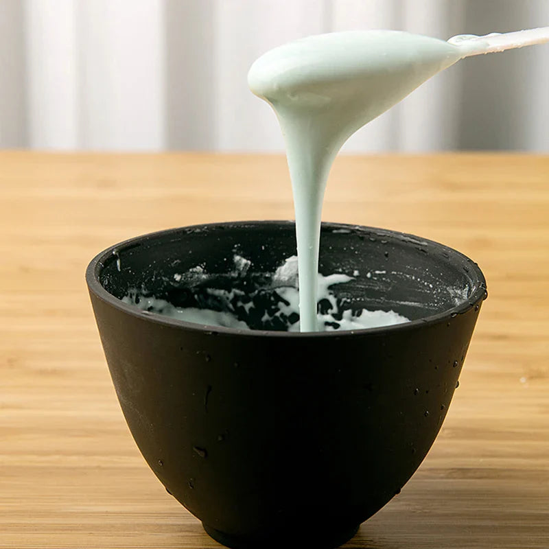 Ciotola nera con crema bianca densa su tavolo di legno, cucchiaio solleva crema. Skincare, maschera viso, bellezza naturale, idratazione pelle.