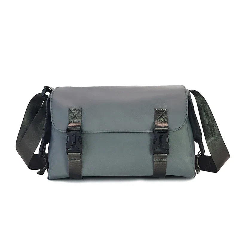 Borsa a tracolla grigia unisex, design moderno, chiusure a fibbia, ideale per lavoro e viaggio. Materiale resistente, tracolla regolabile.