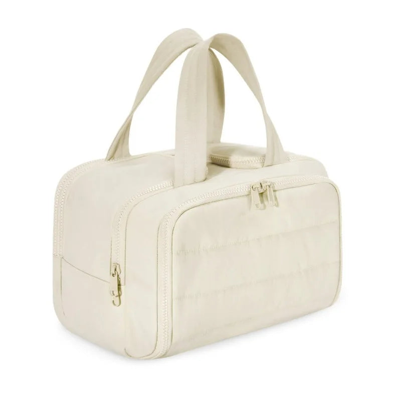 Borsa a mano beige in tessuto trapuntato con doppia zip e manici, design elegante e spazioso, ideale per moda femminile e viaggi.