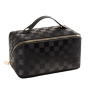Borsa da toilette nera a scacchi con cerniera dorata e manico in pelle, design elegante e moderno, ideale per viaggi e organizzazione.