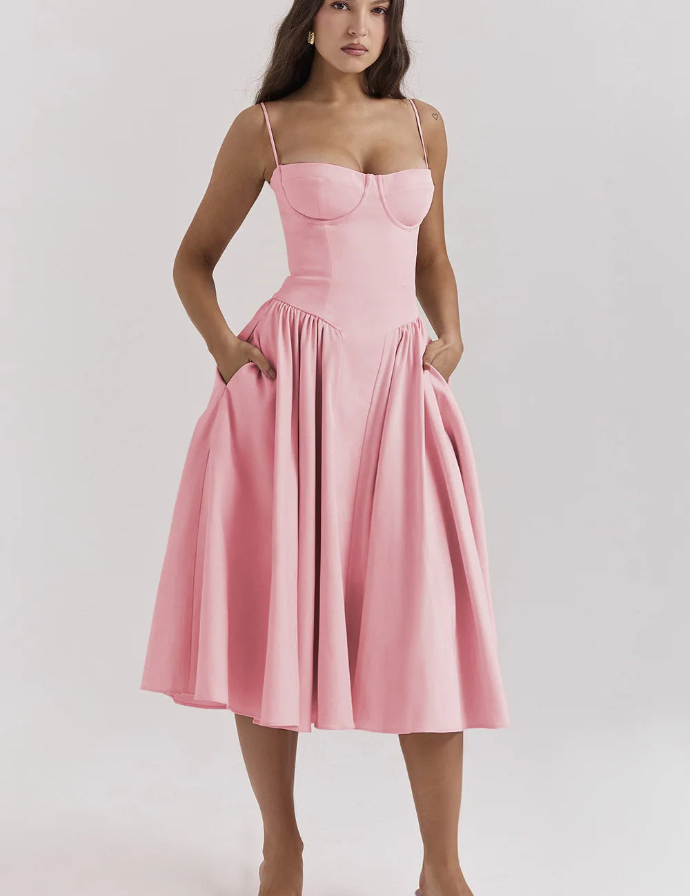 Abito rosa elegante con spalline sottili e gonna ampia, indossato da una donna. Perfetto per eventi formali. Moda femminile, abbigliamento elegante.