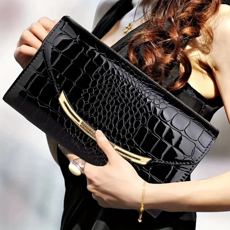 Donna con elegante pochette nera in pelle effetto coccodrillo, dettagli dorati, abito nero. Accessorio moda di lusso, stile sofisticato.