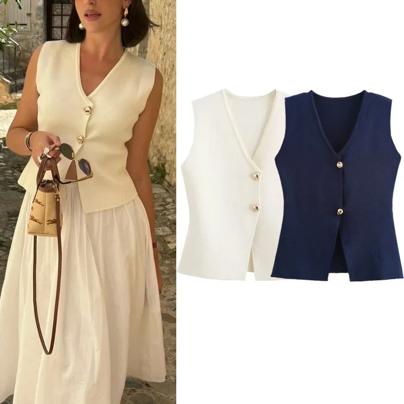 Gilet donna elegante in maglia, disponibile in bianco e blu, con bottoni decorativi. Moda estiva chic, abbinato a gonna bianca e borsa intrecciata.