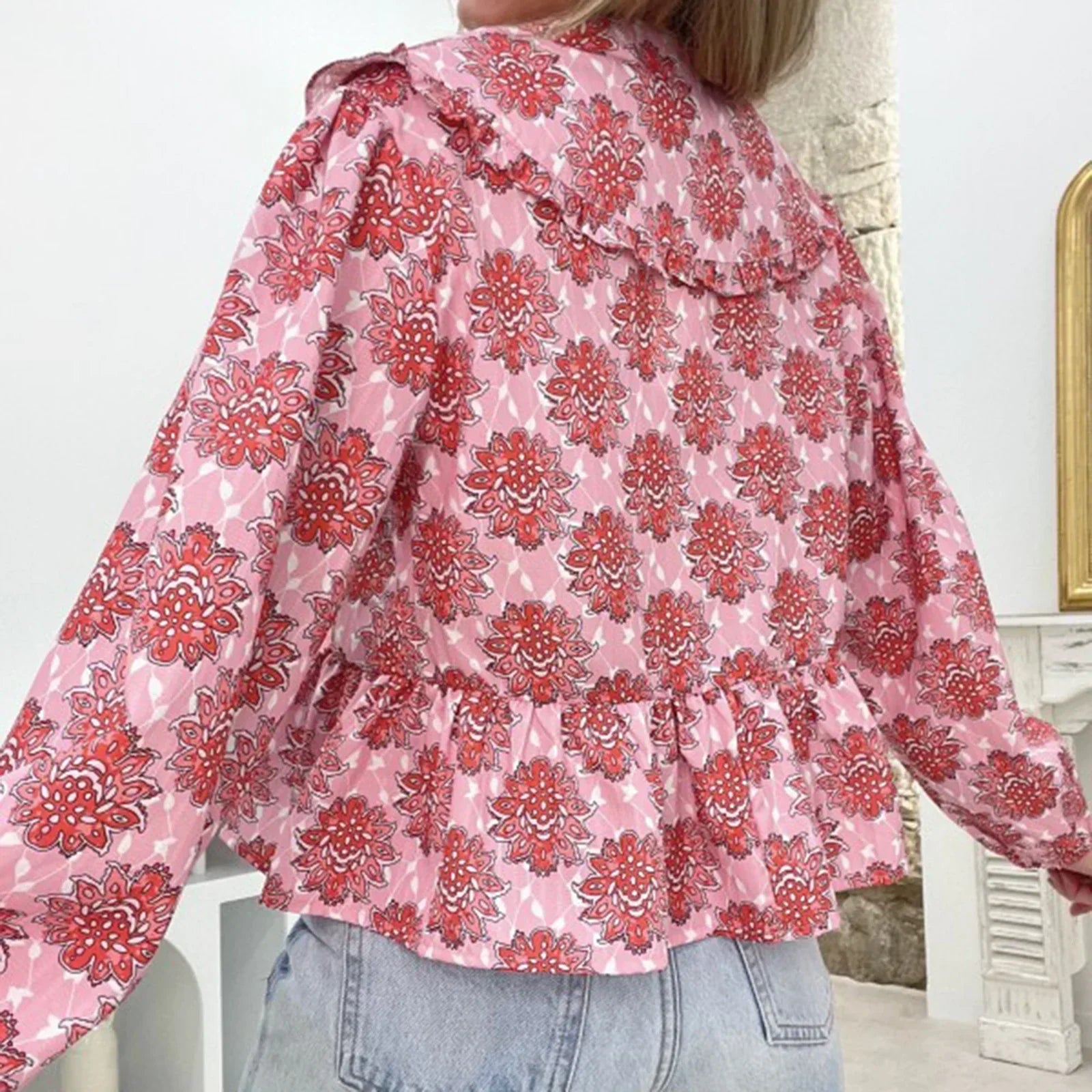 Blusa donna floreale rosa e rossa, maniche lunghe, colletto ampio, abbinata a jeans chiari. Moda femminile, abbigliamento casual elegante.