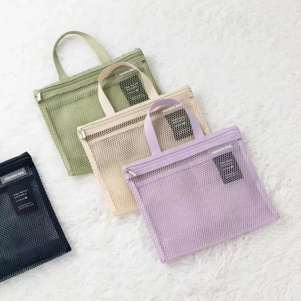 Tre borse a rete colorate su sfondo bianco: verde, beige e lilla. Design moderno, ideali per organizzazione e viaggio. Accessori moda pratici.