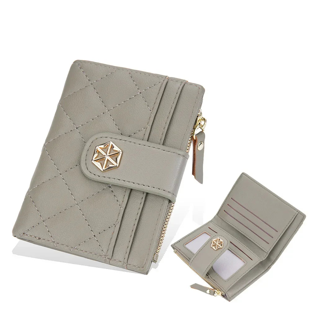 Portafoglio donna in pelle grigia trapuntata, chiusura a zip, scomparti per carte e monete, design elegante e compatto. Accessorio moda femminile.