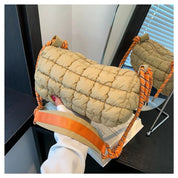 Borsa trapuntata beige con tracolla arancione, design moderno, su specchio. Accessorio moda donna, stile casual chic, perfetto per ogni occasione.