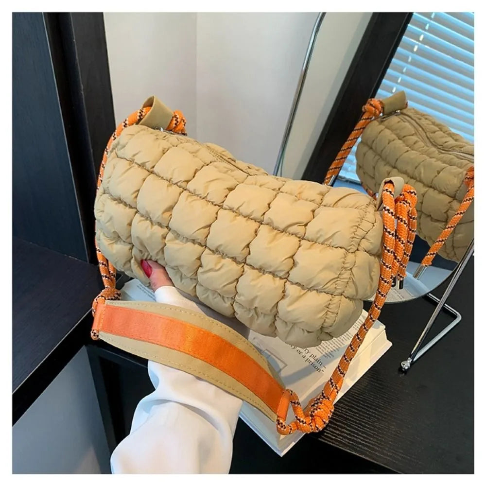 Borsa trapuntata beige con tracolla arancione, design moderno, su specchio. Accessorio moda donna, stile casual chic, perfetto per ogni occasione.